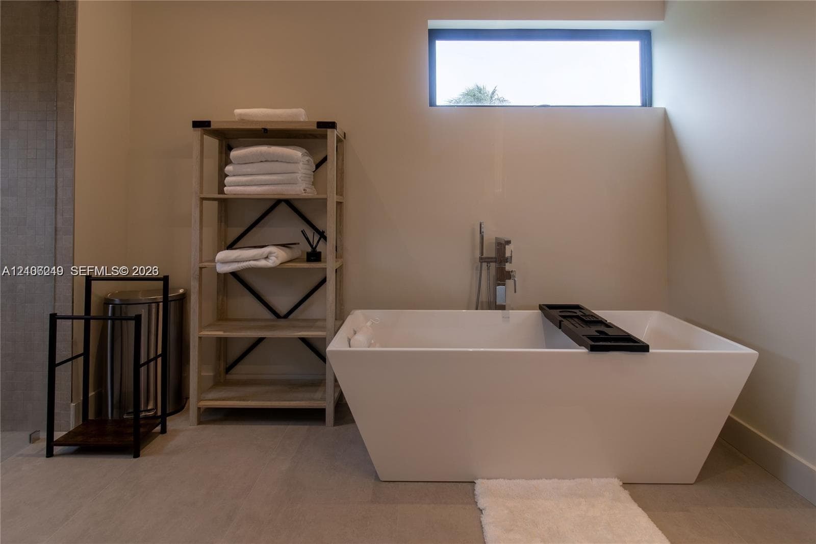 Freestanding rectangular soaking tub with a floor-mounted faucet and high-positioned horizontal clerestory window