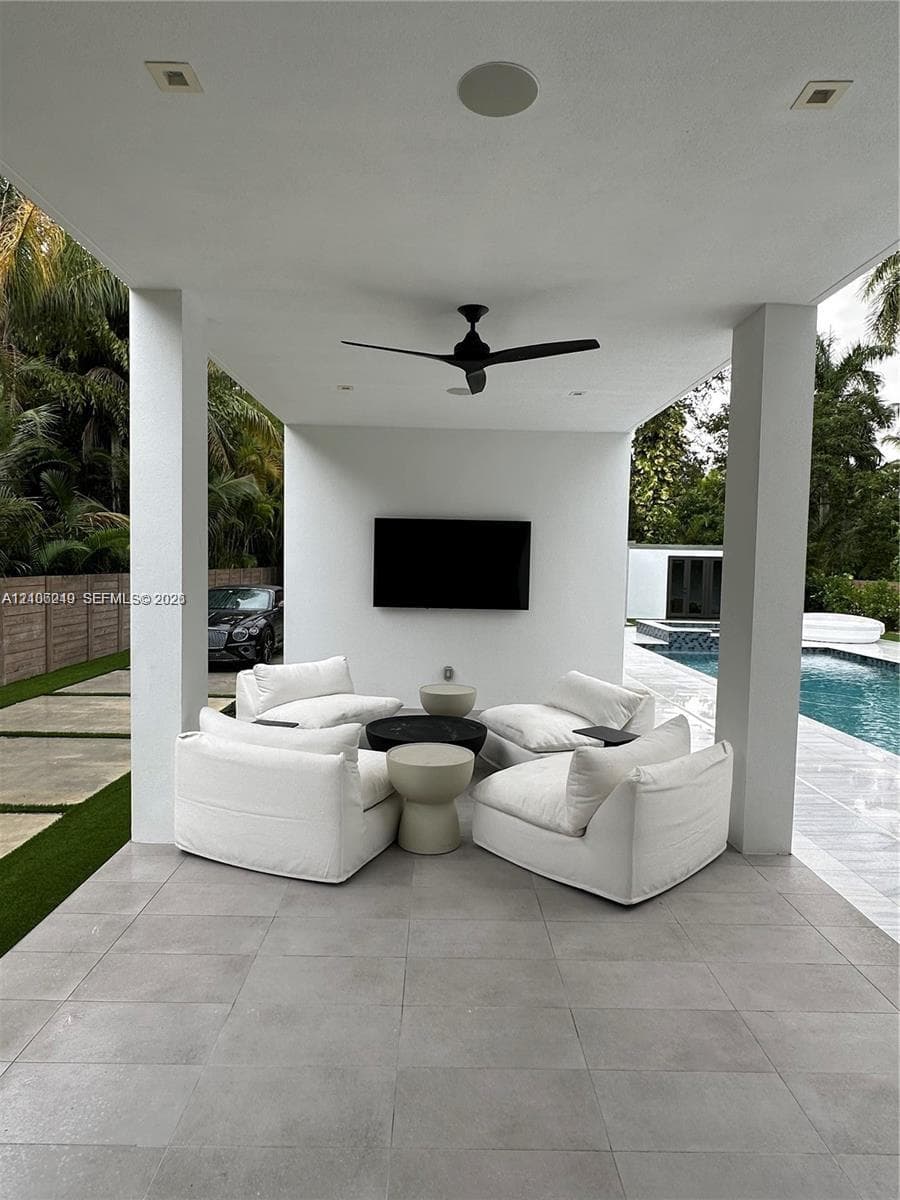 Covered patio featuring large-format porcelain tile flooring, recessed lighting, ceiling fan, and a mounted wall display