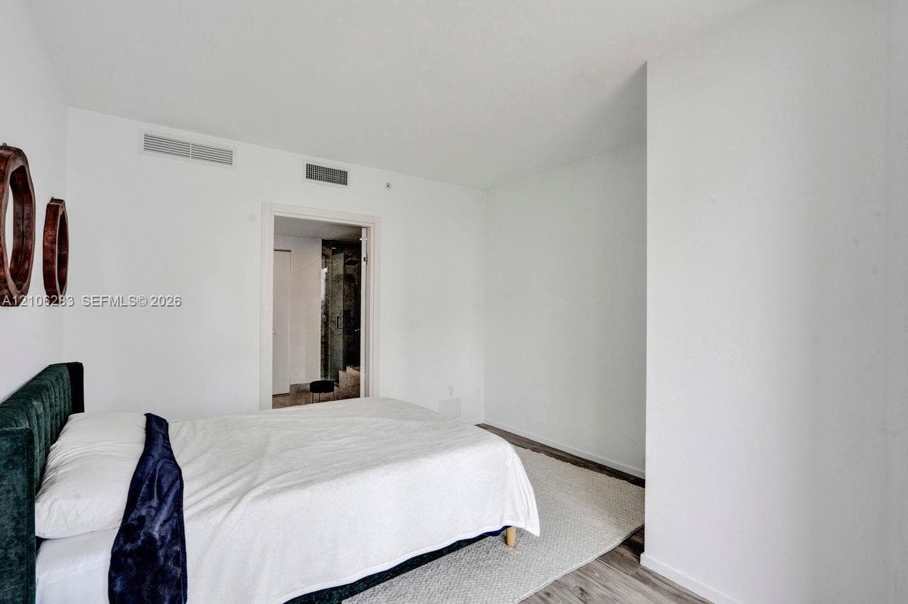 Room featuring white walls and wood-finish flooring