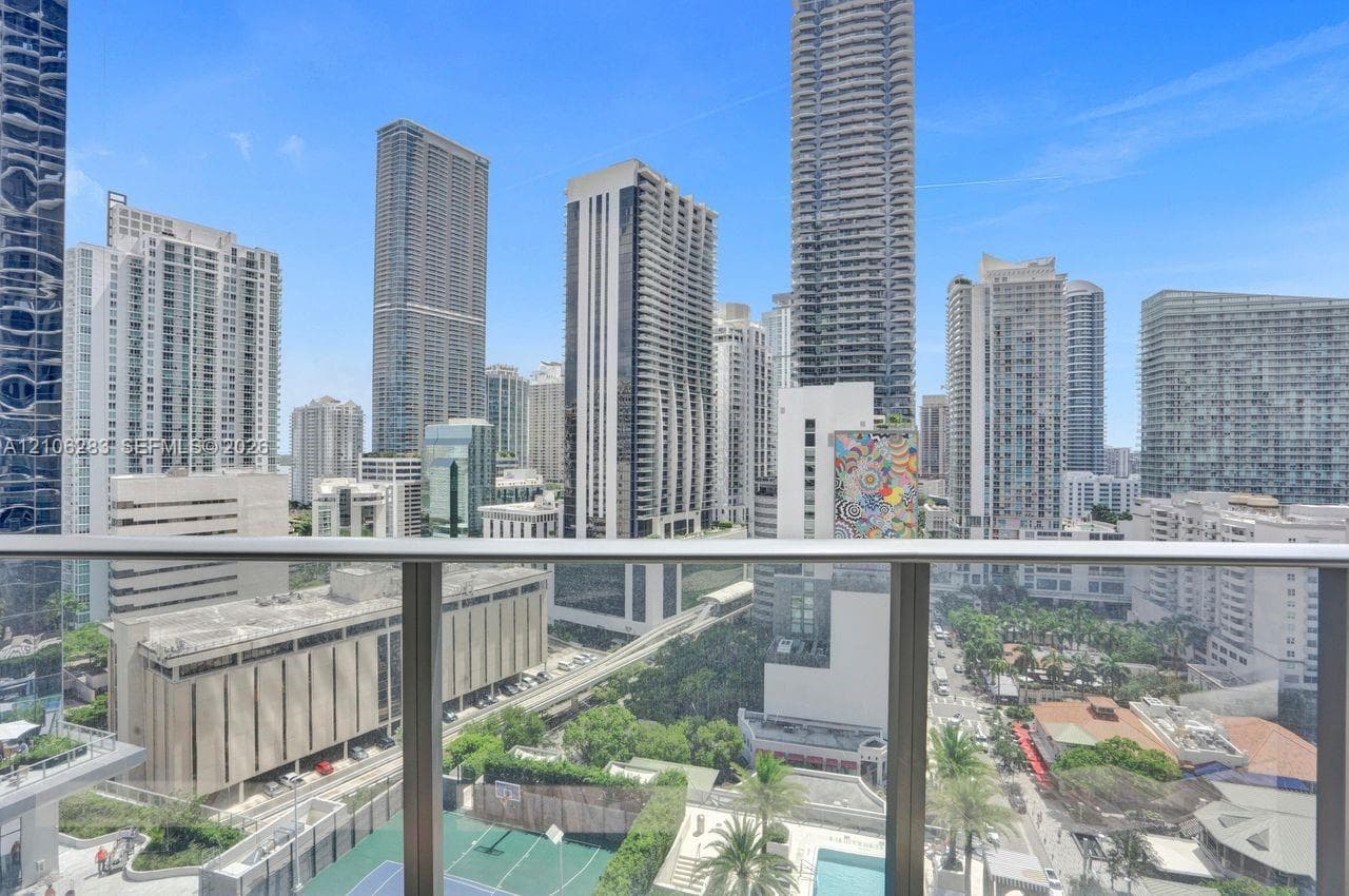 Balcony with a brushed metal and glass railing, featuring an expansive urban skyline panorama