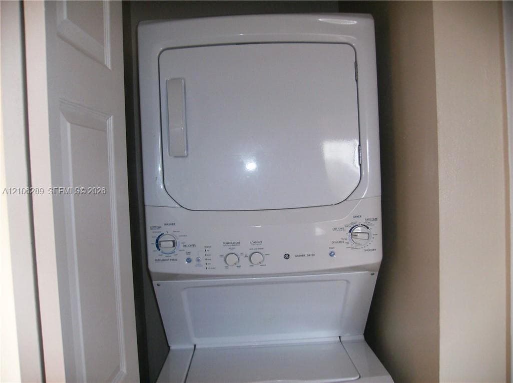White stackable washer and dryer unit with rotary controls and top-loading basin