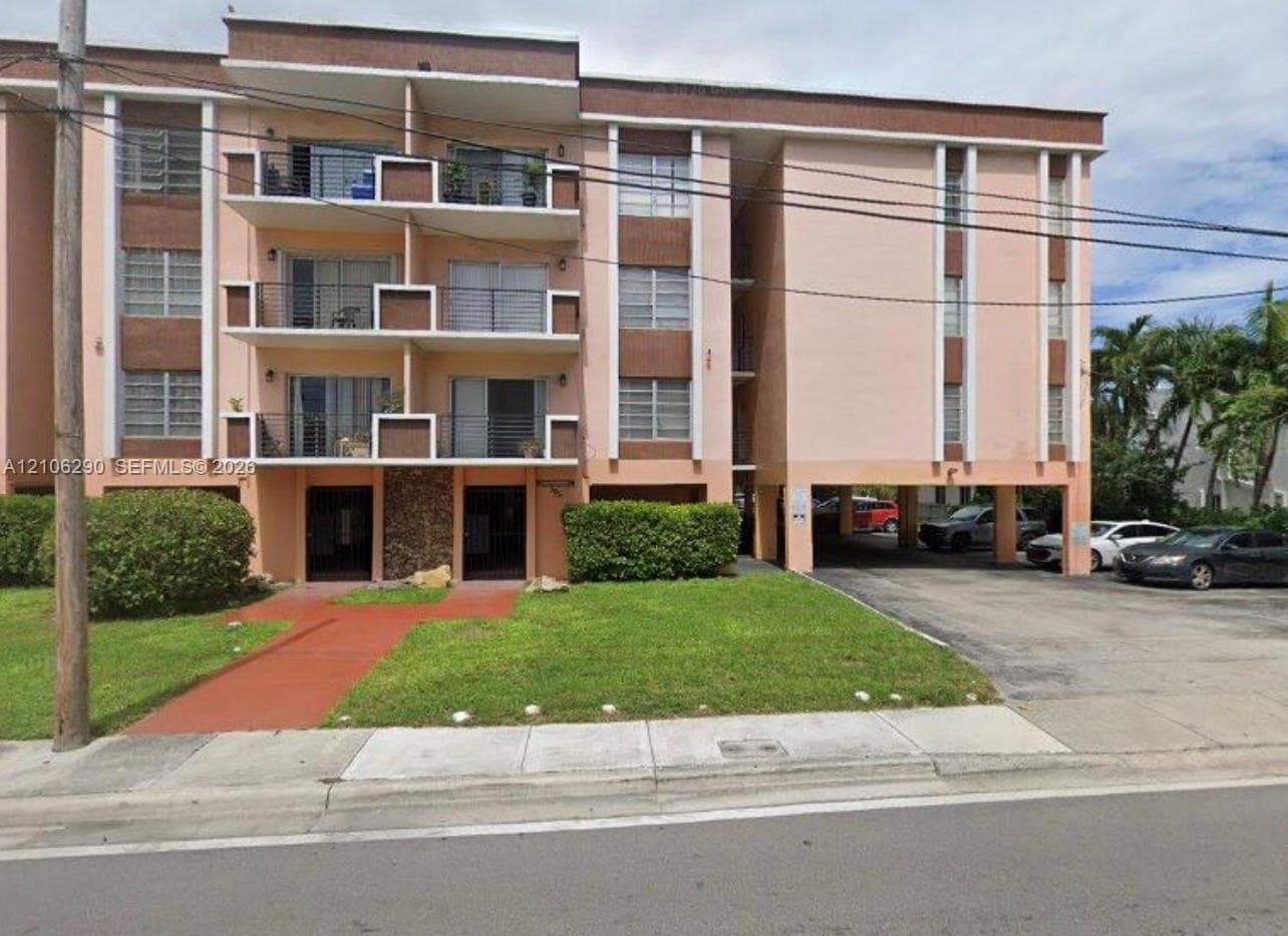 Multi-story residential building featuring private balconies, stone accent exterior detailing, and covered ground-level parking