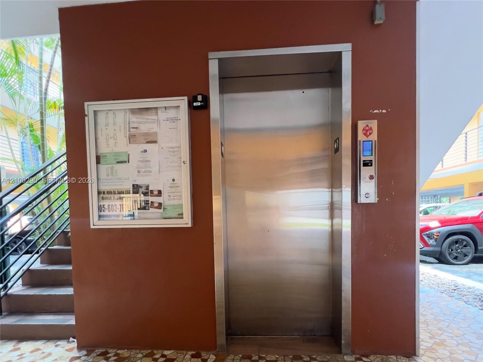 Stainless steel elevator with a digital interface panel, mounted on a solid-surface wall