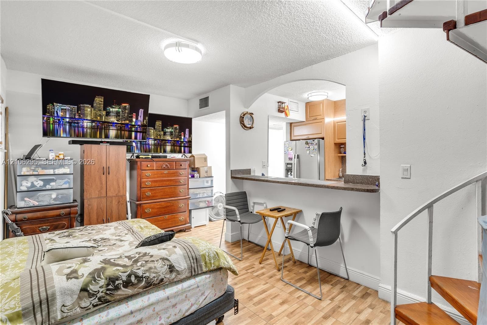 Kitchen featuring a pass-through breakfast bar, wood-finish flooring, and a spiral staircase with wood treads