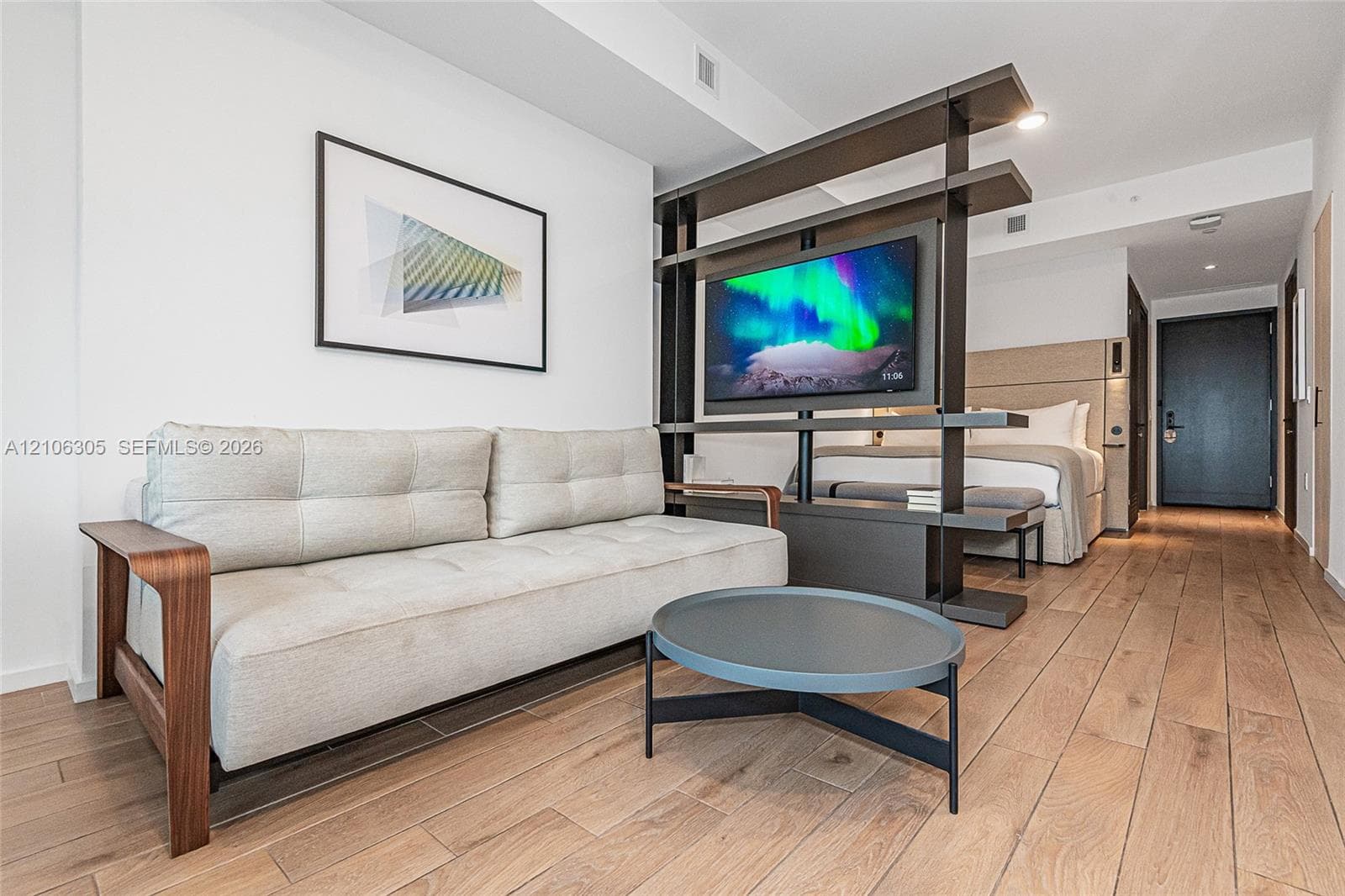 Wood-finish flooring throughout, integrated built-in shelving partition, and recessed ceiling lighting
