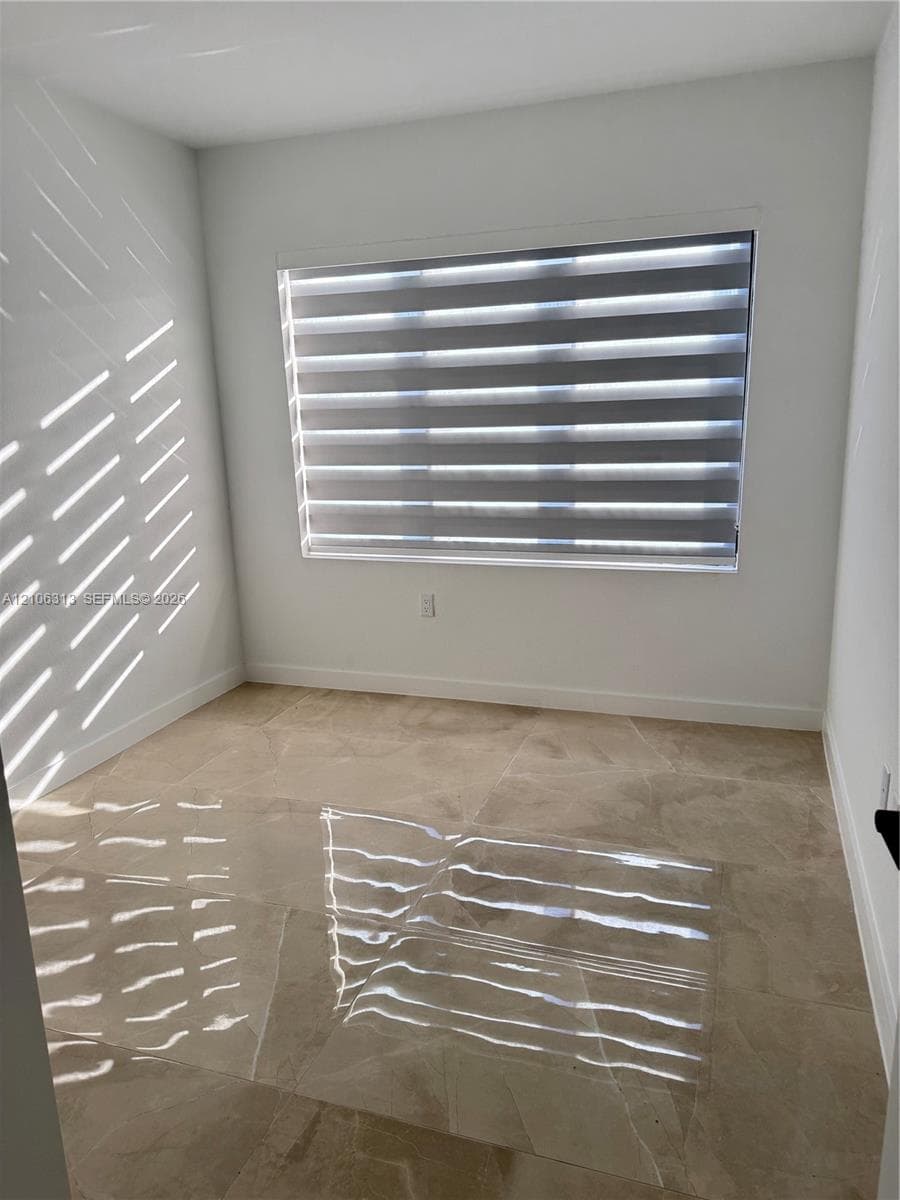 Neutral-toned large format tile flooring and crisp white wall finishes
