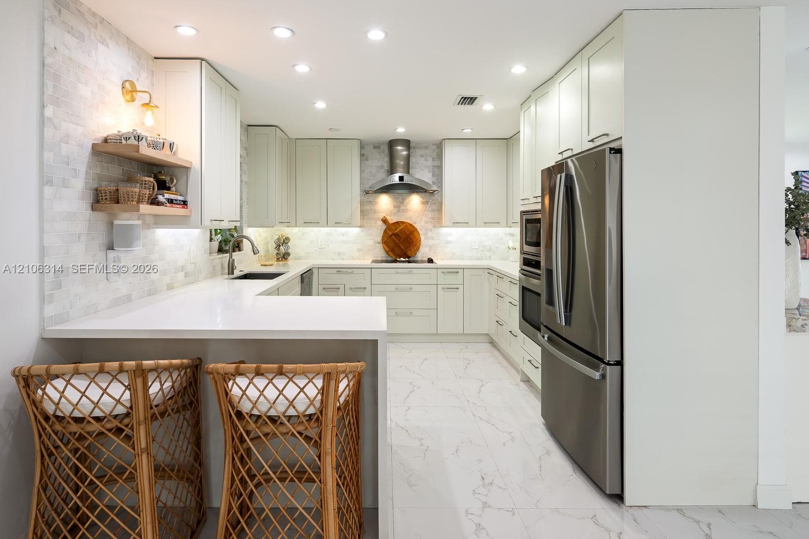 Kitchen featuring white shaker-style cabinetry, quartz countertops, mosaic tile backsplash, stainless steel appliances, and large-format tile flooring