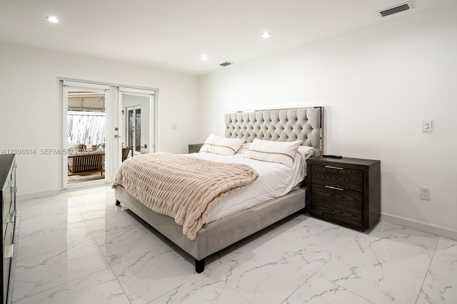 Polished large-format tile flooring, recessed lighting, and glass-paneled double doors featuring exterior access