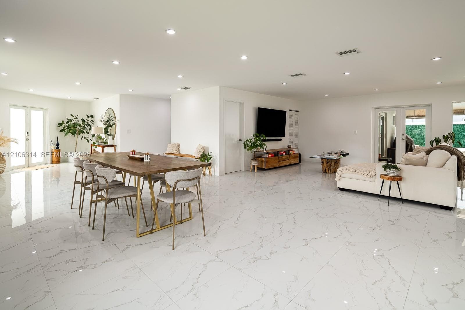 Large-format tile flooring with veining detail, recessed lighting, and double glass-paned doors