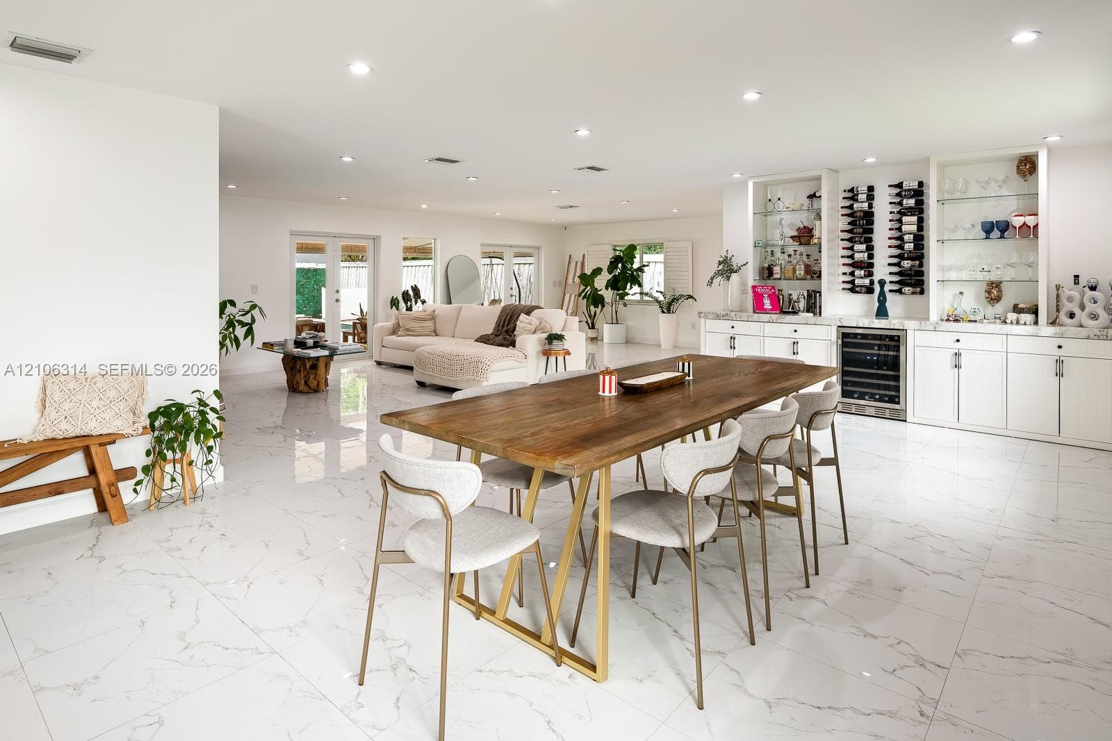 Large-format tile flooring, recessed lighting, and custom built-in cabinetry featuring integrated wine storage and glass display shelving