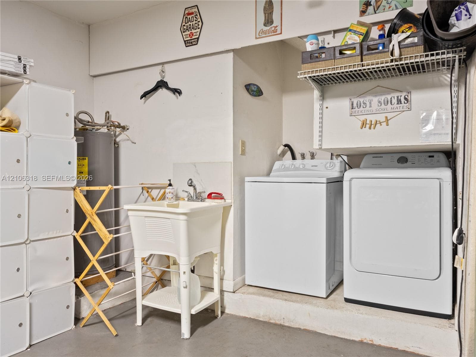 Utility area featuring a freestanding basin sink with a high-arch faucet, wall-mounted wire shelving, and dedicated laundry hookups