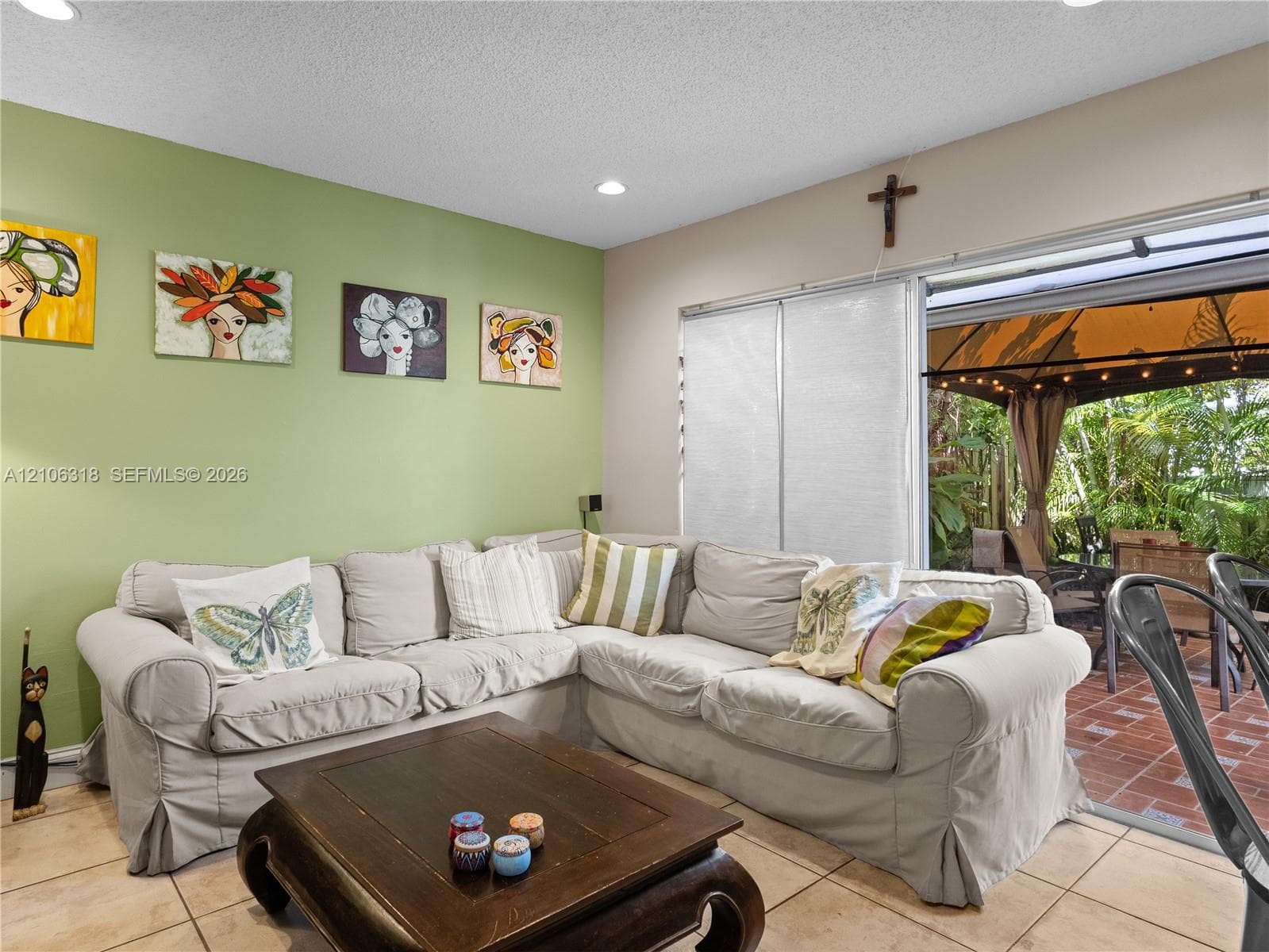 Ceramic tile flooring, recessed ceiling lighting, and expansive sliding glass doors providing outdoor access