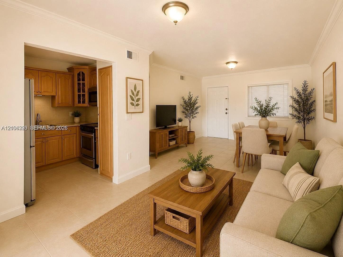 Open-concept layout featuring neutral ceramic tile flooring, crown molding, and wooden cabinetry with glass-front detailing