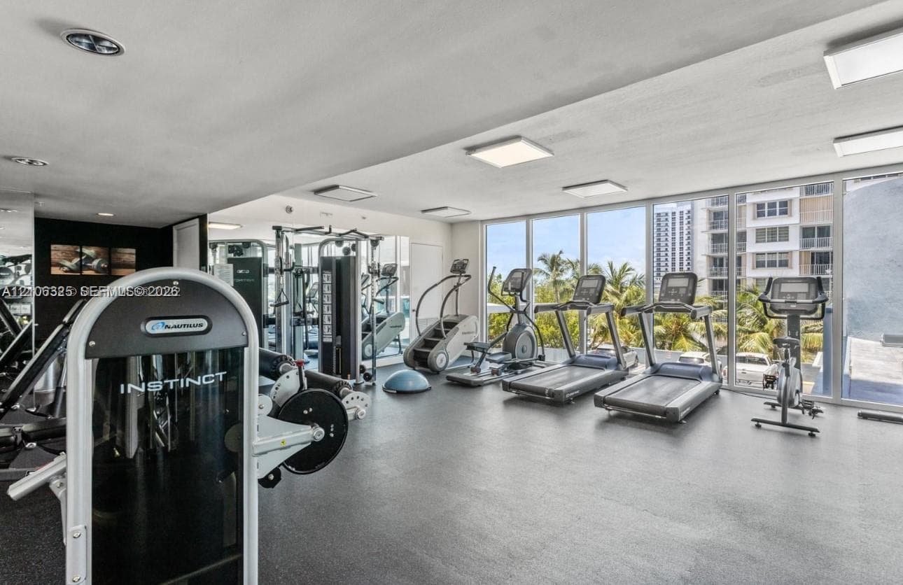 Fitness center featuring floor-to-ceiling windows, rubberized flooring, and recessed ceiling lighting