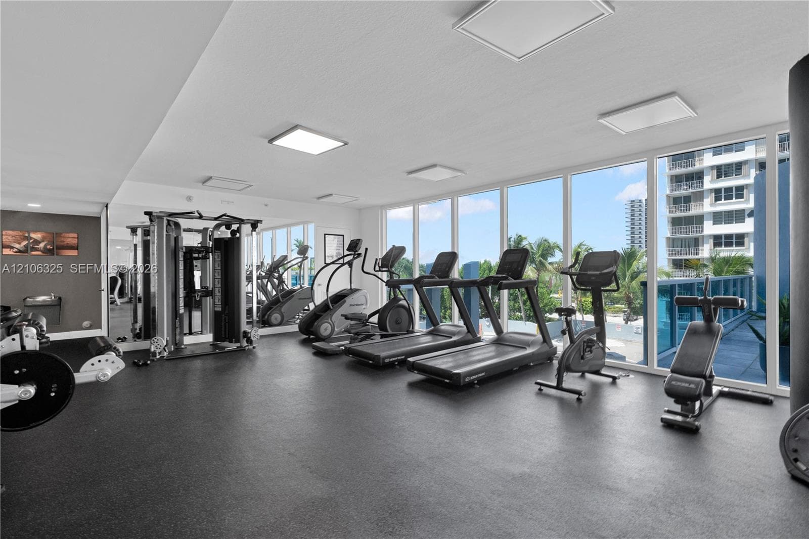 Fitness center featuring floor-to-ceiling windows, rubberized flooring, and recessed lighting