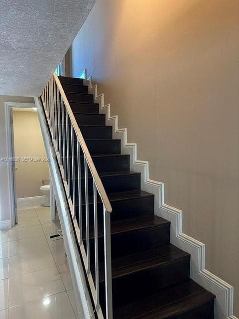 Staircase featuring dark wood-finish treads, white structural railing, and decorative wall molding