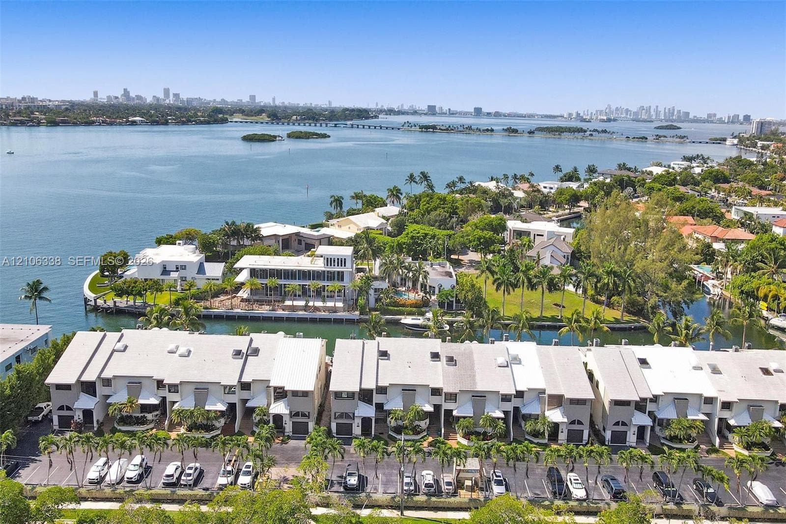 Aerial perspective featuring direct waterfront access, a bulkhead-reinforced shoreline, mature tropical landscaping, and a multi-level residential structure