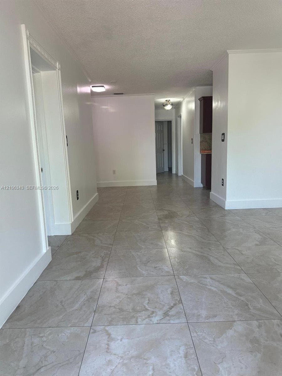 Large-format stone-style tile flooring, neutral wall finishes, and flush-mount lighting fixtures
