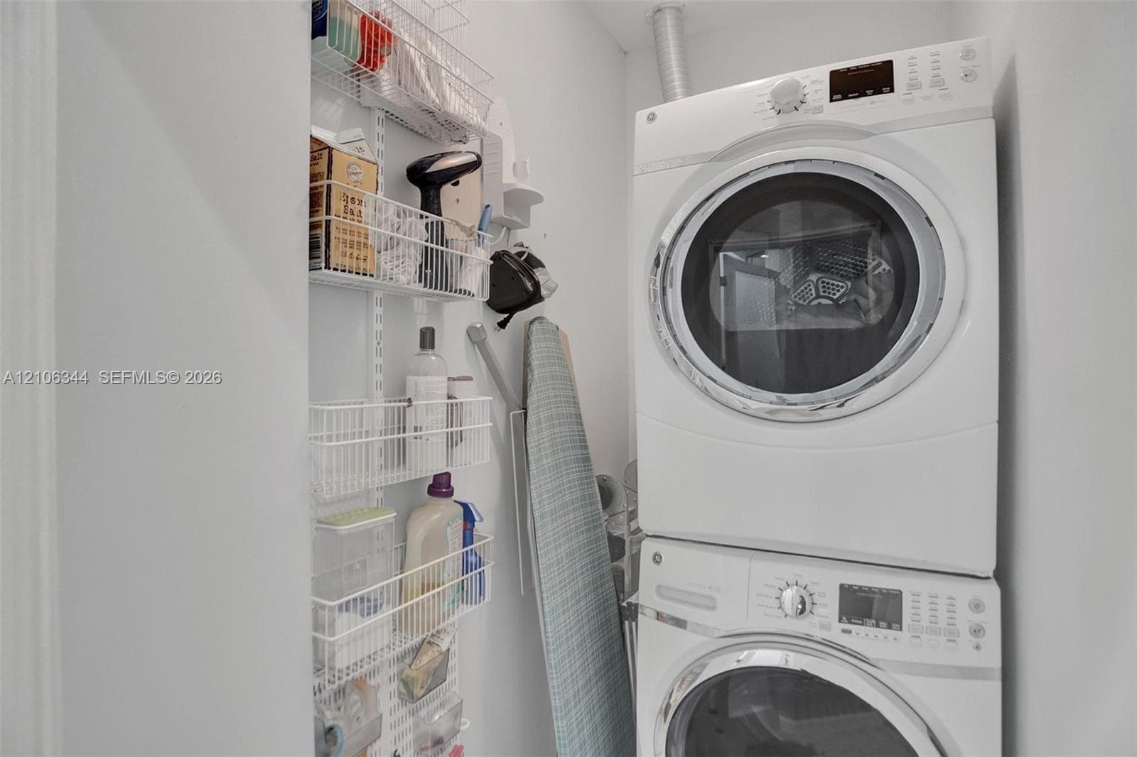 Stacked front-load washer and dryer unit with wall-mounted wire storage shelving