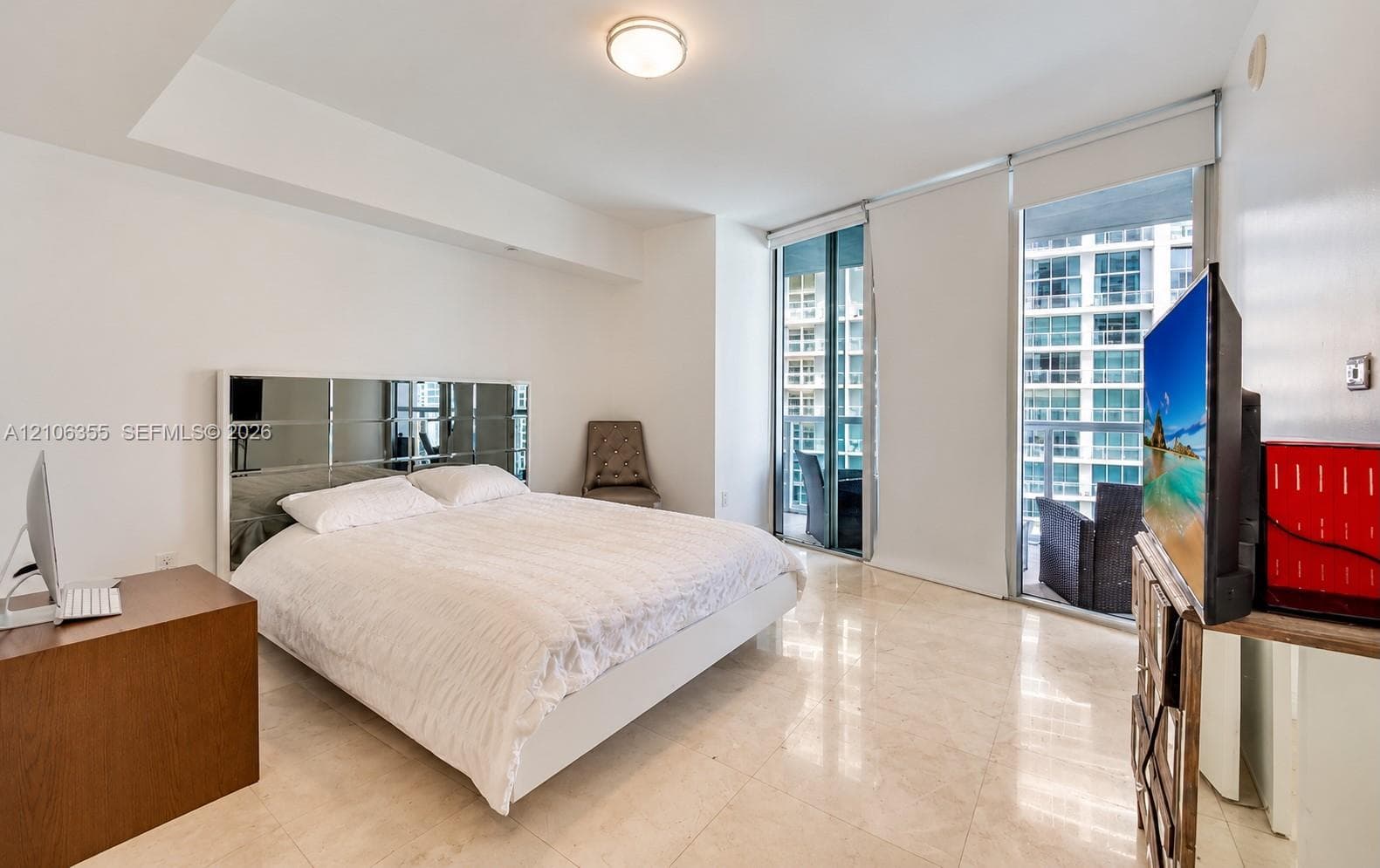 Light-filled room featuring large-format tile flooring, recessed ceiling lighting, and floor-to-ceiling glass sliding doors providing external access