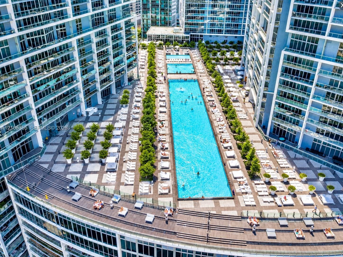 Elevated terrace featuring a rectangular swimming pool, integrated landscaping, and expansive tiled deck space