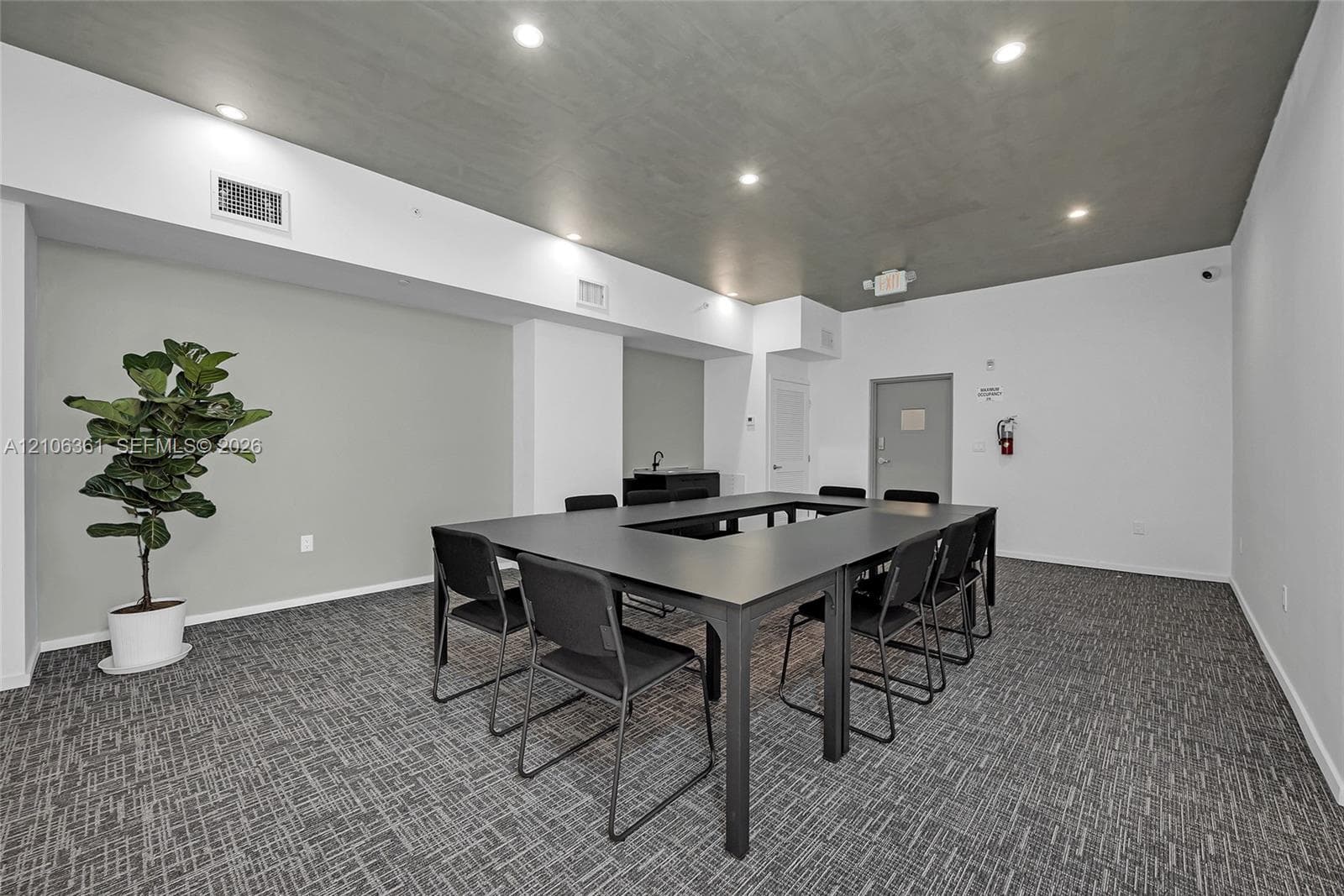 Neutral-toned interior featuring a recessed ceiling, recessed lighting, and patterned carpeted flooring