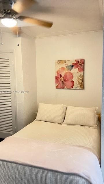 Interior space featuring a ceiling-mounted light fixture with fan blades and a closet with louvered doors