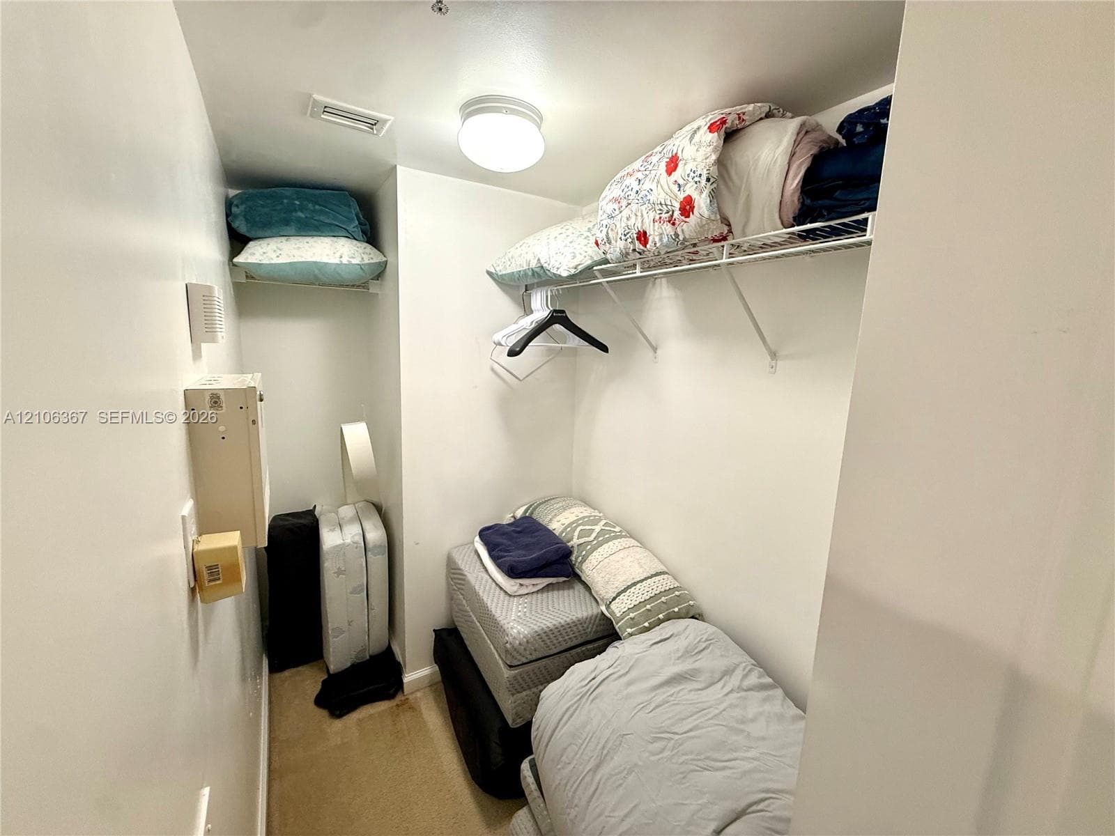 Storage space featuring built-in wire shelving and a ceiling-mounted light fixture