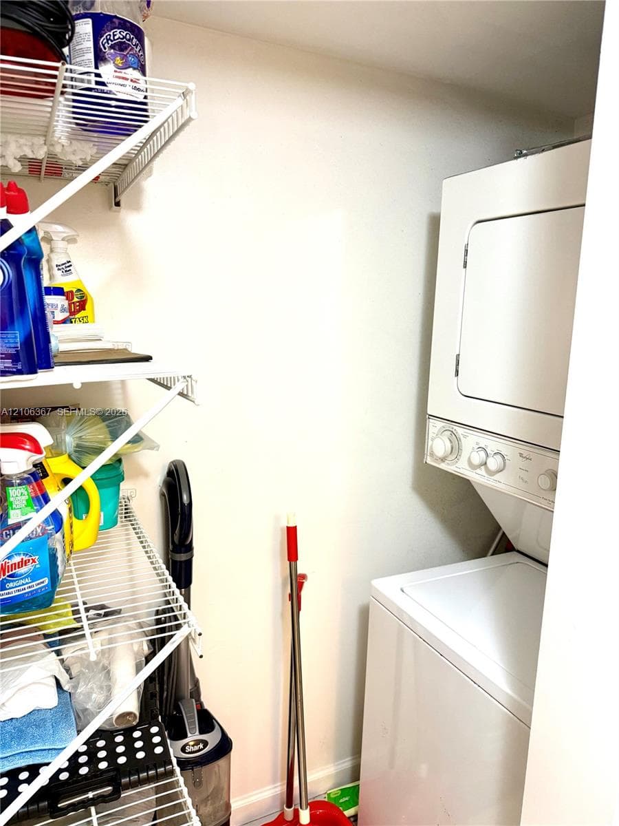 Stackable laundry unit featuring white appliance finish and integrated multi-tier wire shelving