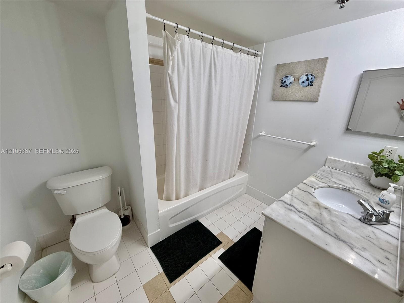 Bathroom featuring a vanity with a white-veined countertop, integrated sink, tub-shower combination, and tiled flooring