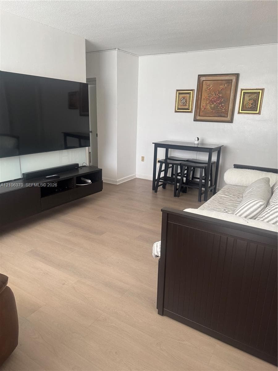 Open-concept living space featuring wood-finish flooring and a wall-mounted console cabinet