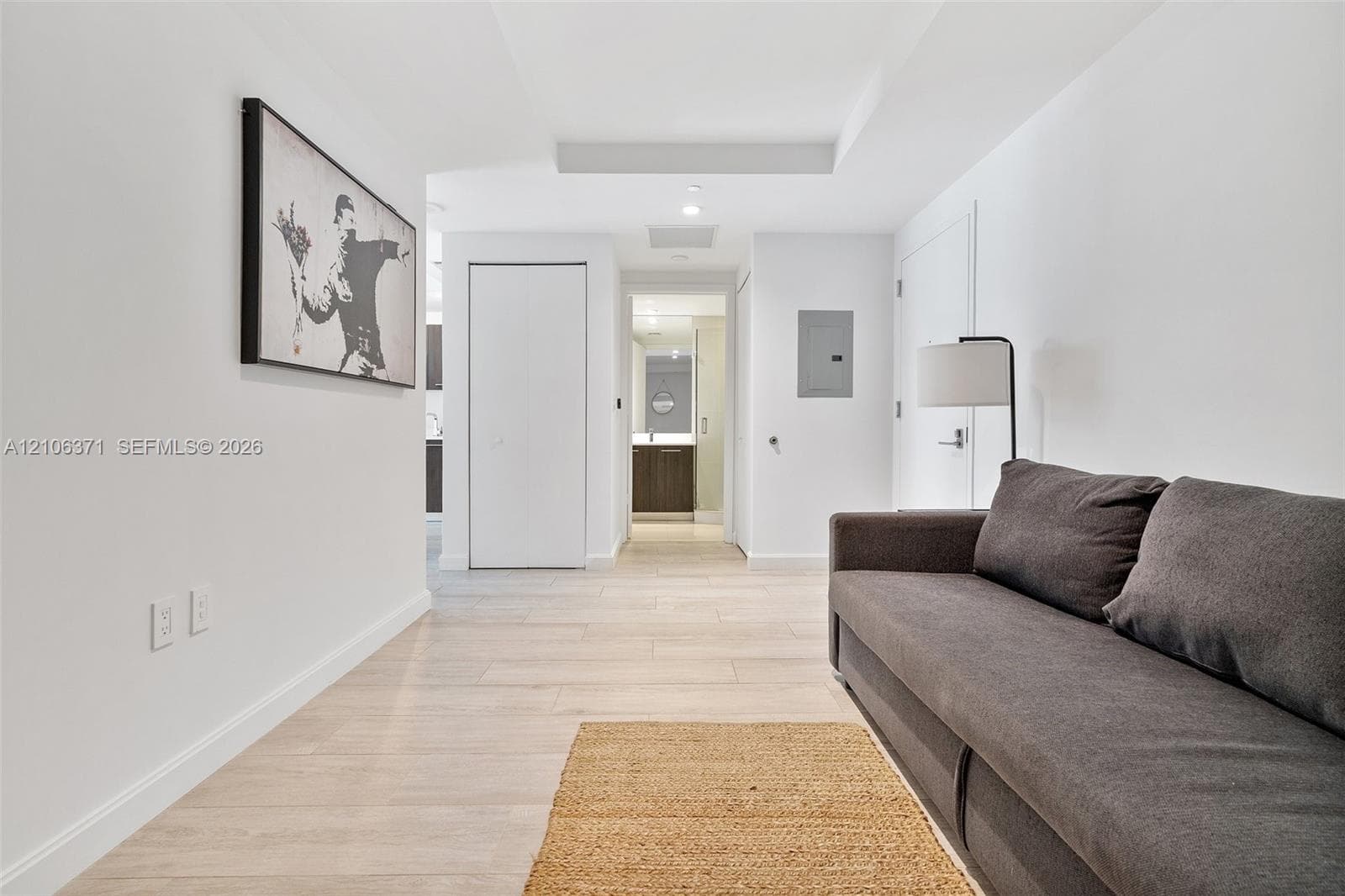Interior hallway featuring wood-finish flooring, recessed ceiling lighting, and crisp white wall finishes