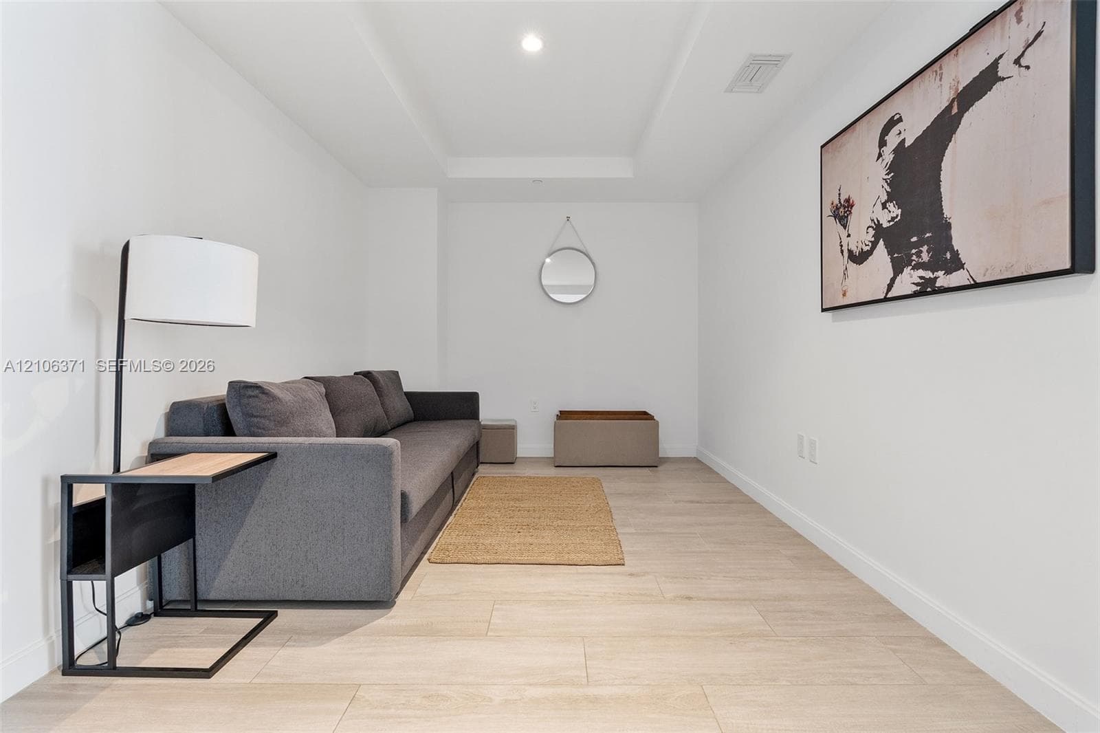 Wood-finish flooring, recessed ceiling lighting, and a tray ceiling