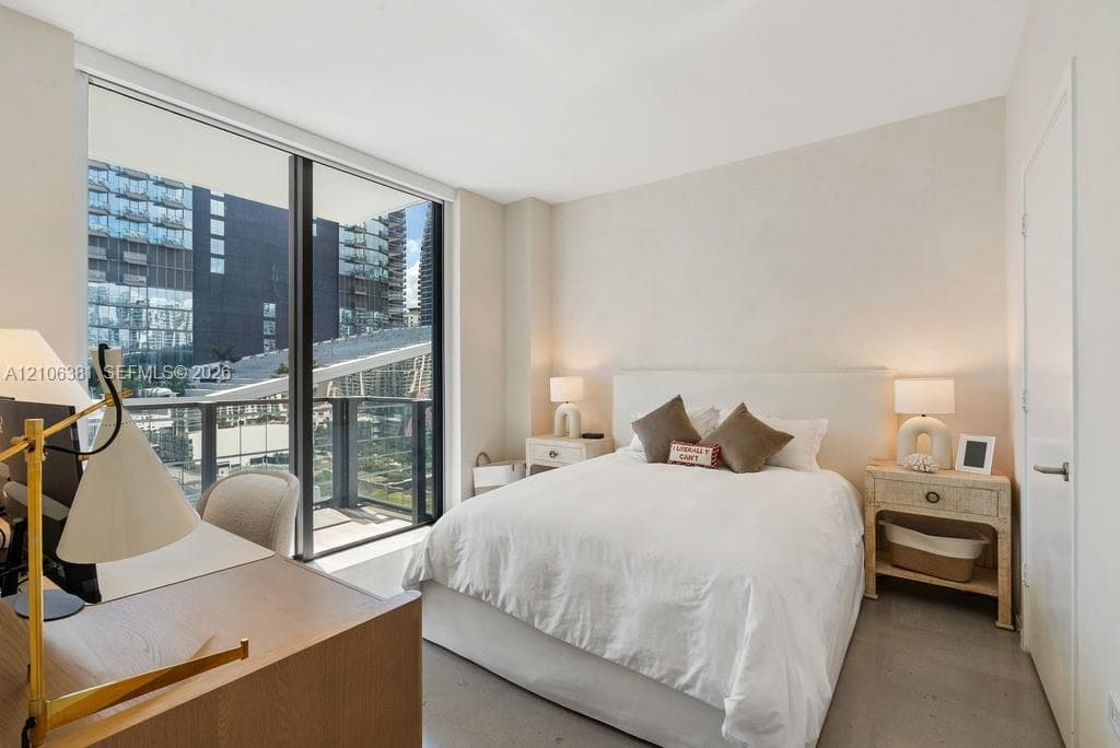 Floor-to-ceiling windows, private balcony, neutral interior palette, and polished concrete flooring