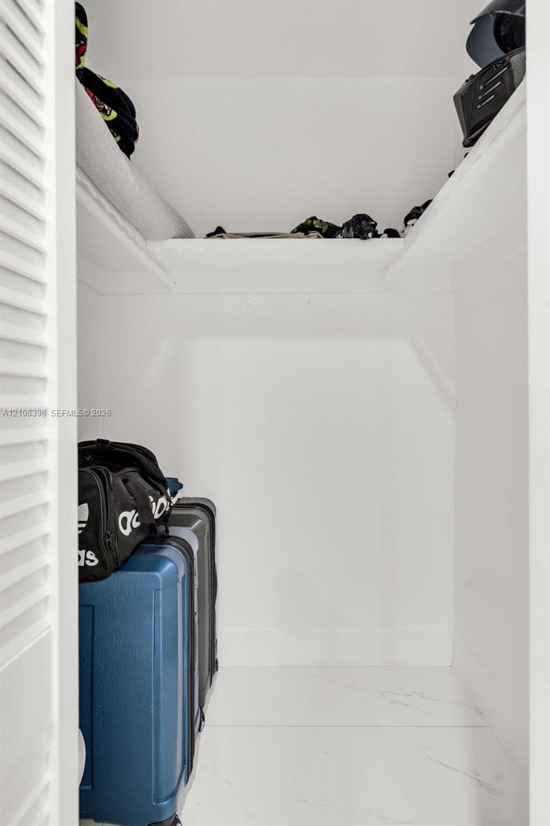 Closet featuring louvered bifold doors and built-in upper shelving