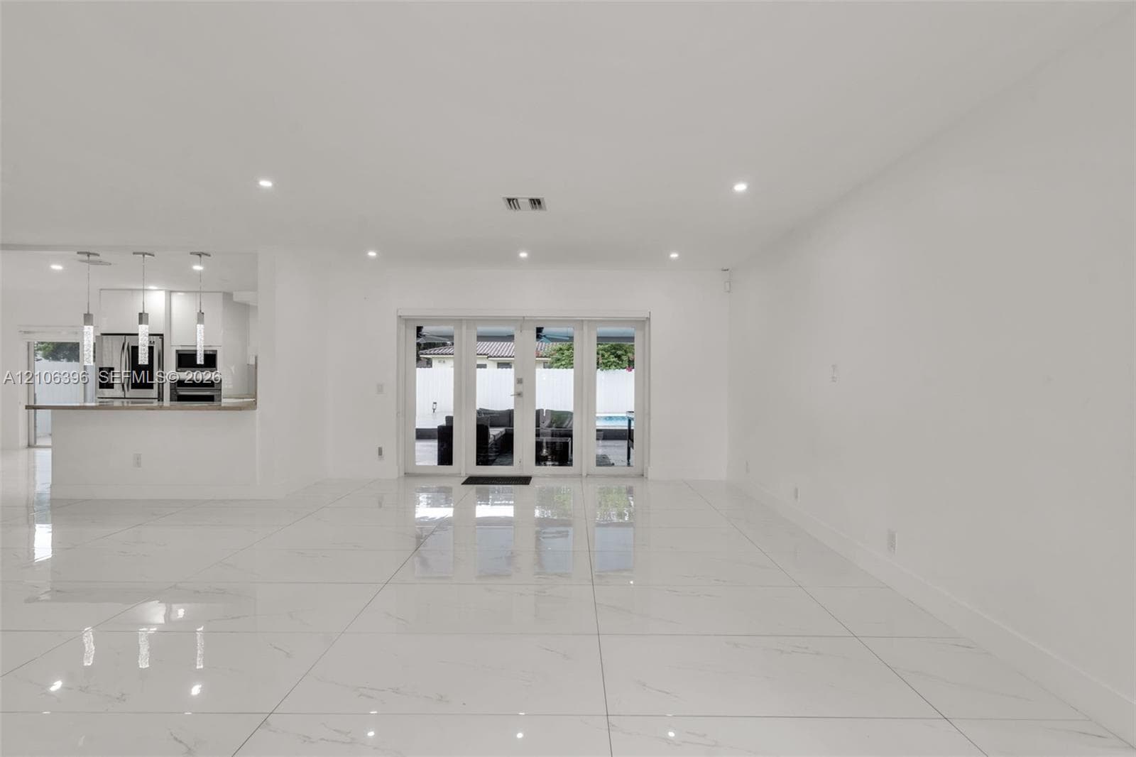 Large-format tile flooring, recessed ceiling lighting, and multi-panel glass door system
