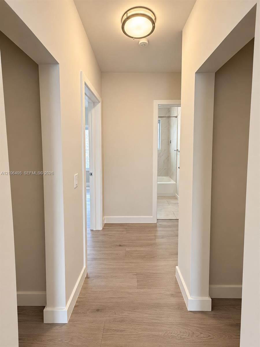 Neutral wall color, wood-finish flooring, and flush-mount ceiling lighting