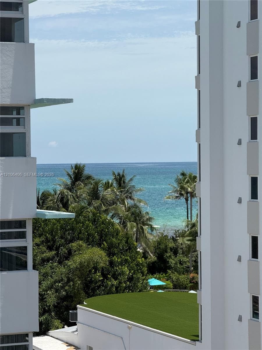 Oceanfront corridor framing the horizon, featuring mature palm trees and manicured elevated turf landscaping