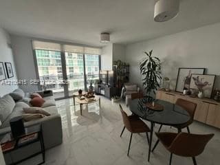 Large-format polished tile flooring, floor-to-ceiling glass sliding doors, and neutral wall tones