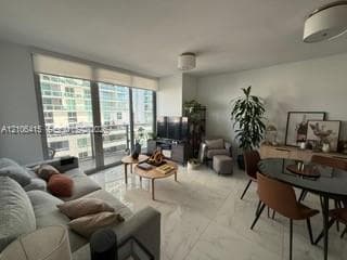 Floor-to-ceiling windows, large-format stone-finish tile flooring, and neutral wall tones