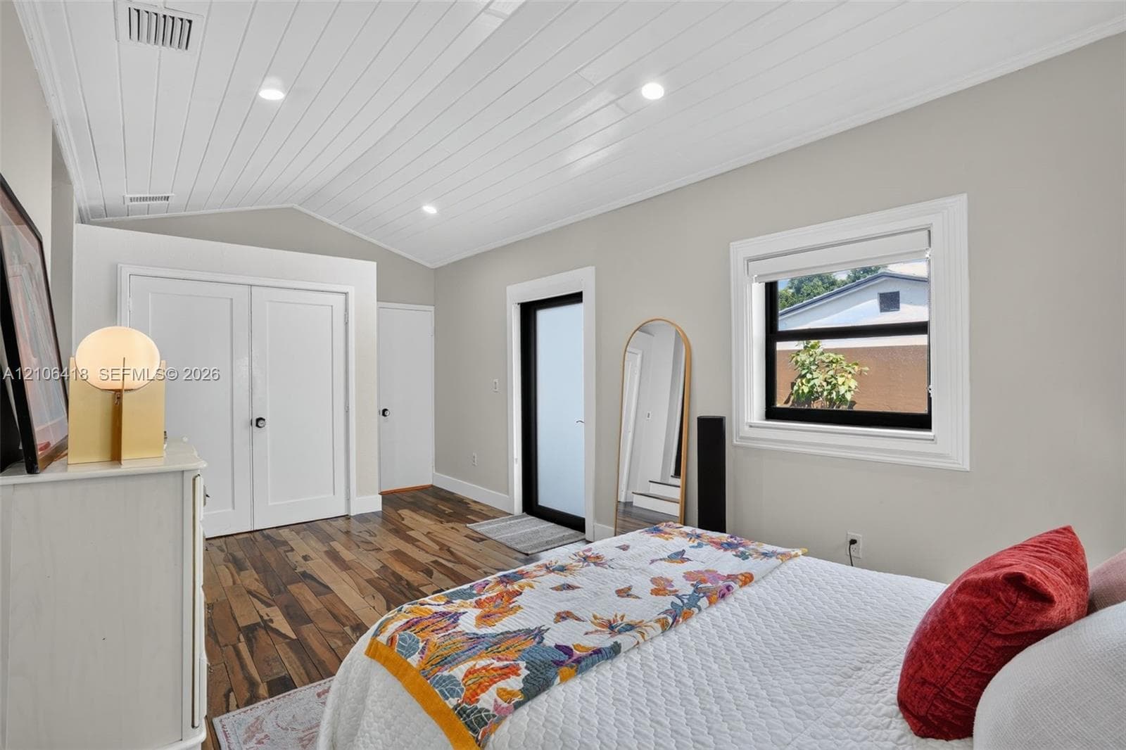 Vaulted ceiling with tongue-and-groove planking, recessed lighting, wood-finish flooring, and a glass-paneled exterior door