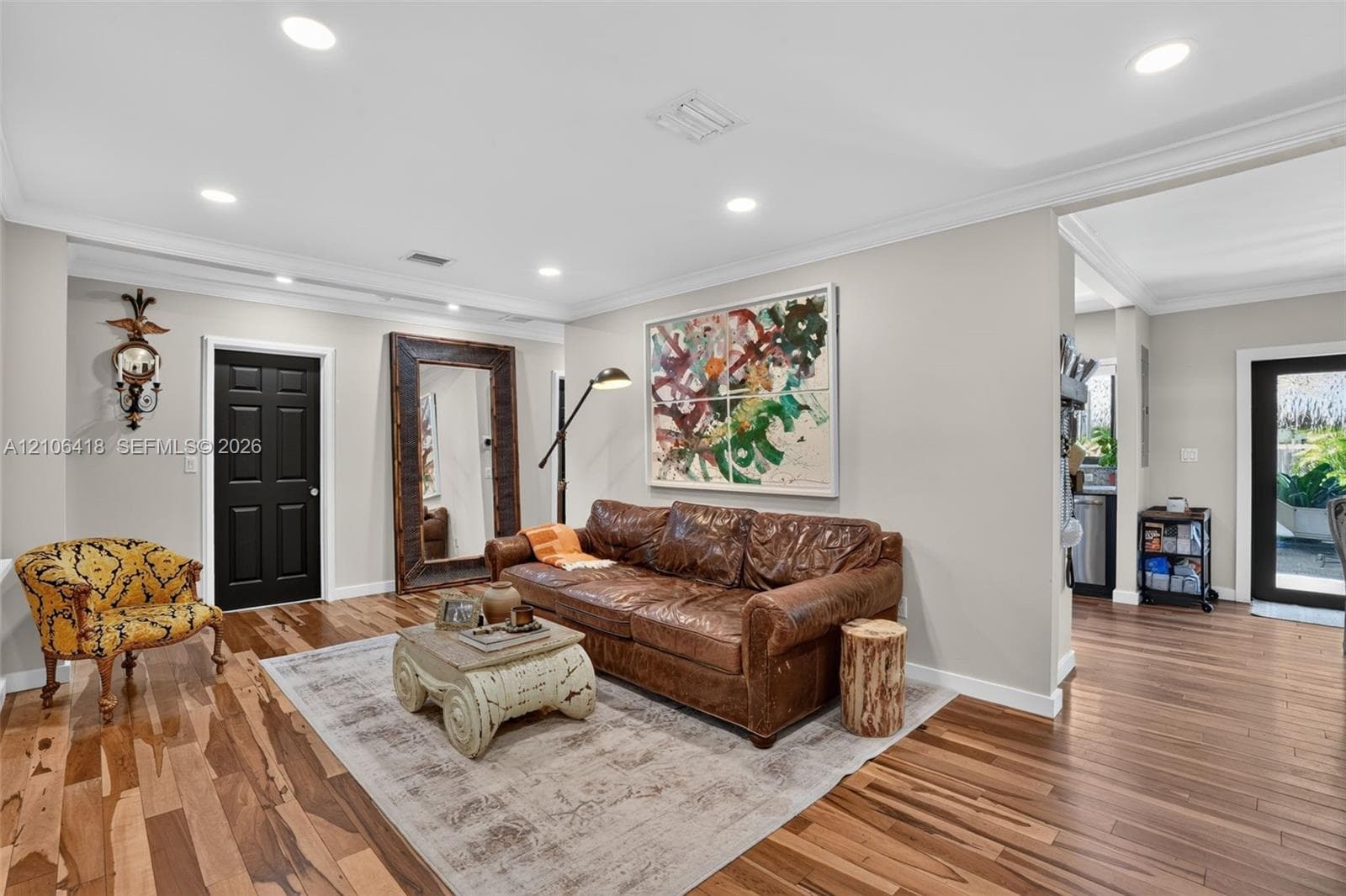 Wood-finish flooring, recessed lighting, crown molding, and solid-core interior doors with dark finish
