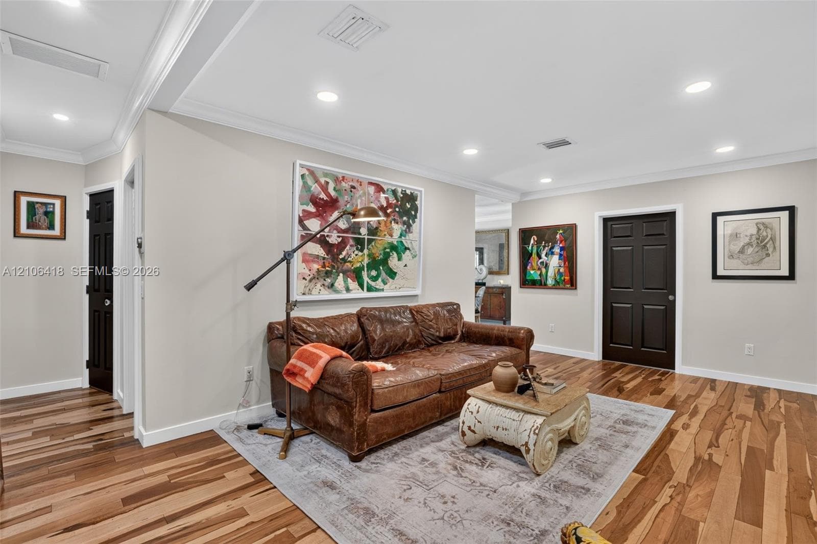 Wood-finish flooring, crown molding, recessed lighting, and multi-panel interior doors