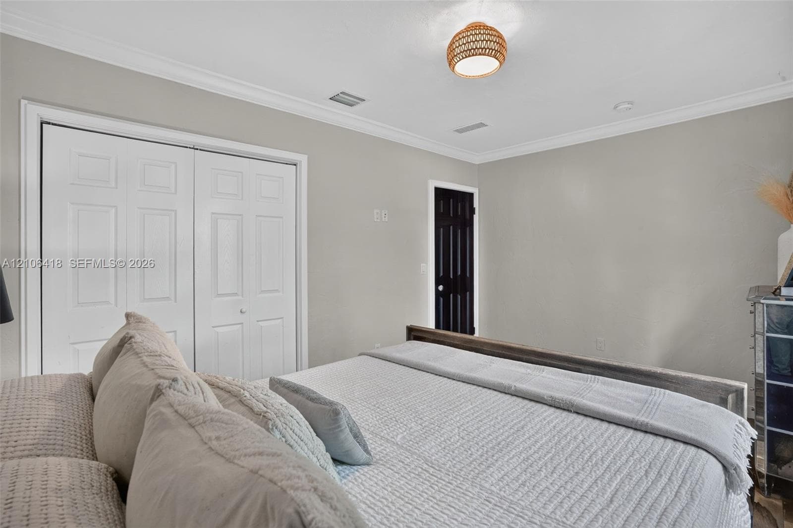 Room featuring crown molding, neutral wall finishes, closet with double-panel doors, and a woven-textured dome light fixture
