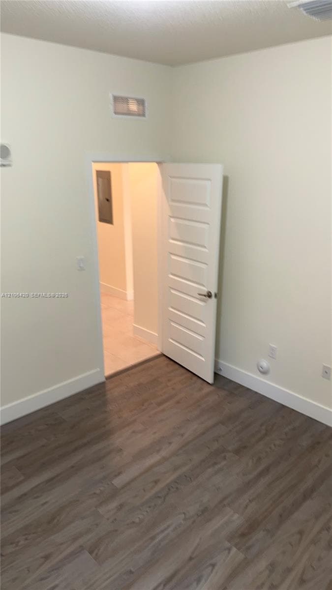 Interior space featuring wood-finish flooring, a neutral wall color palette, and a paneled interior door