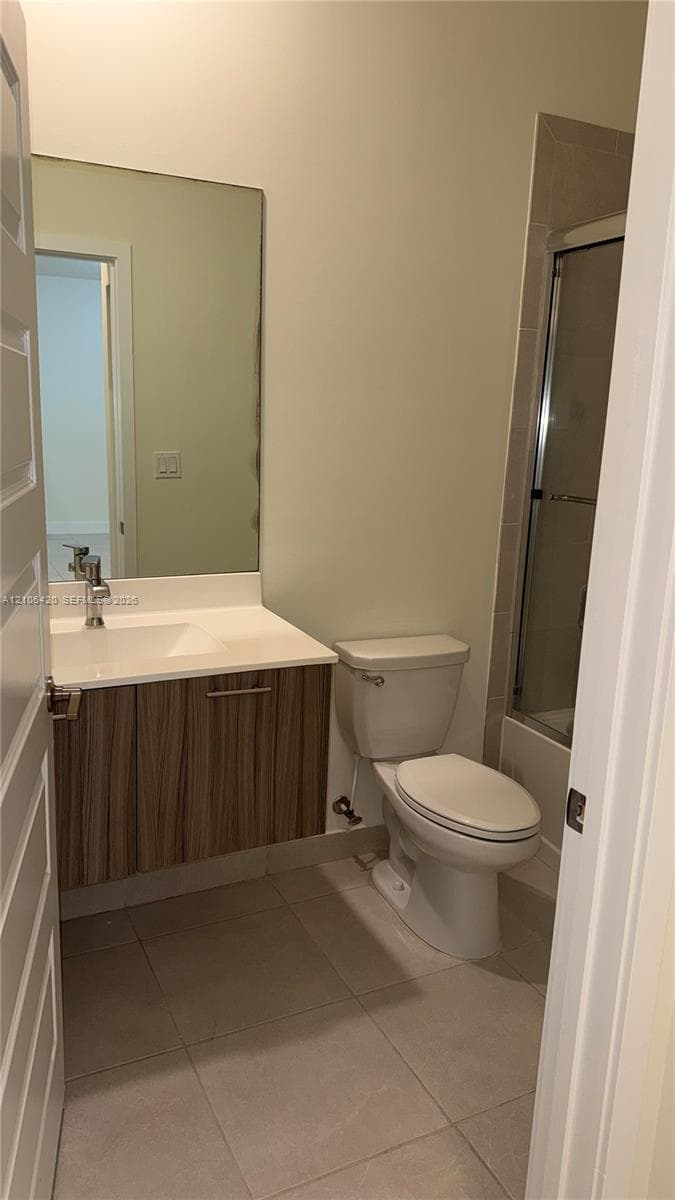 Floating vanity with wood-finish cabinetry, rectangular under-mount sink, large wall-mounted mirror, and tile flooring