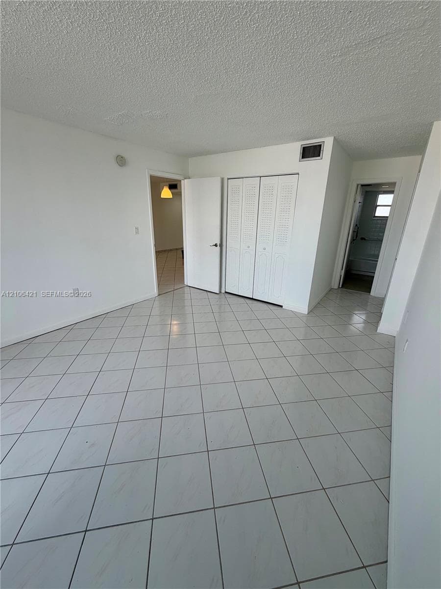 Interior space featuring ceramic tile flooring, bifold closet doors, and solid-core interior doors