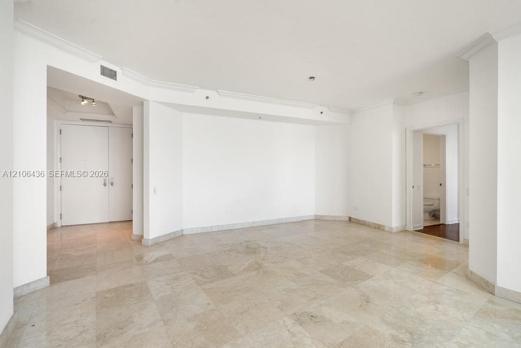 Open interior featuring stone tile flooring, crown molding, and recessed lighting