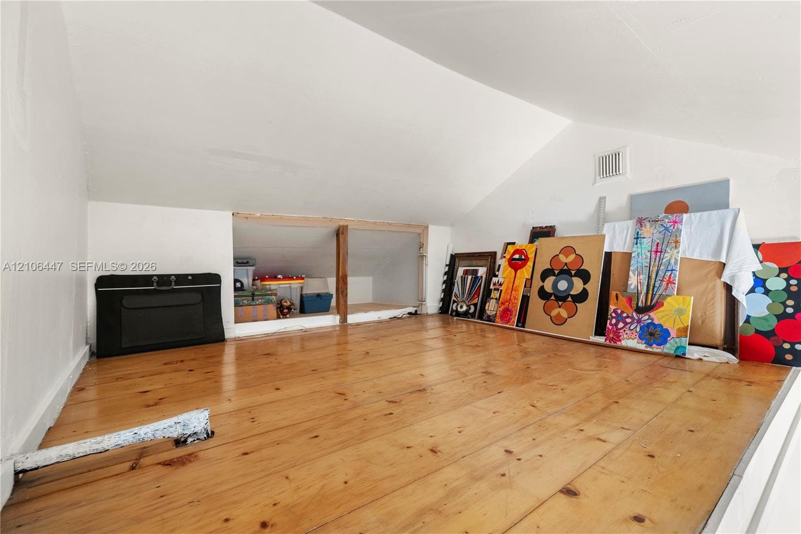 Loft area featuring sloped ceilings and wood-finish flooring