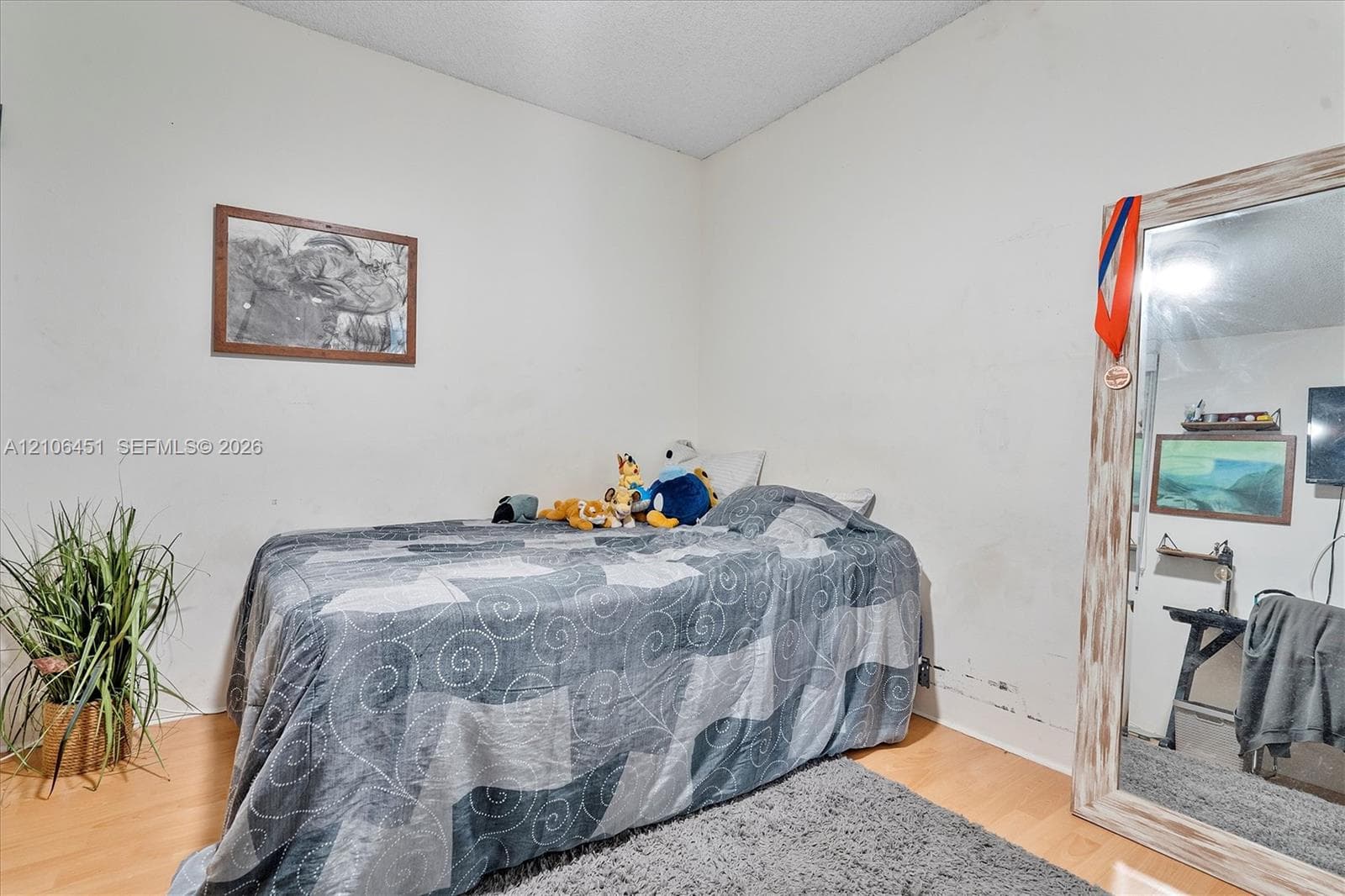 Room featuring wood-finish flooring and neutral-toned wall paint